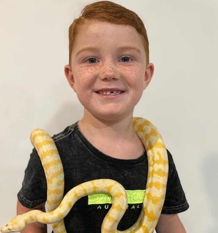 Young Boy Holding a Snake — Frozen Feeders in NSW